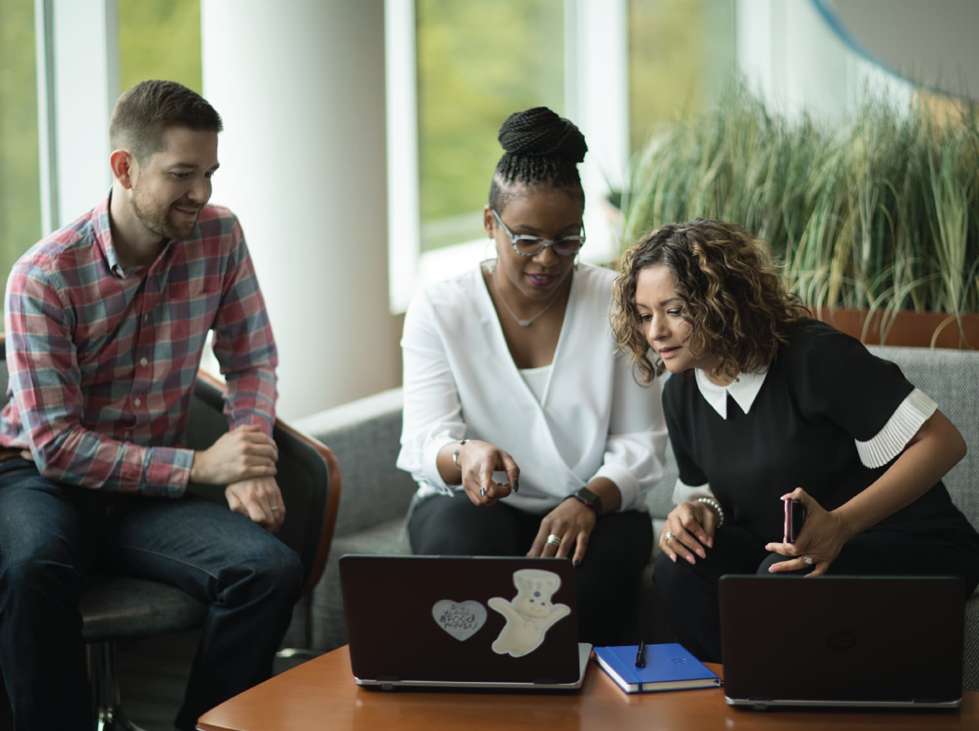 Three employees looking at laptop